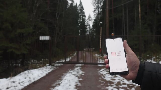 User's hands open outdoor gate using smart home mobile app, right view. High quality 4k footage