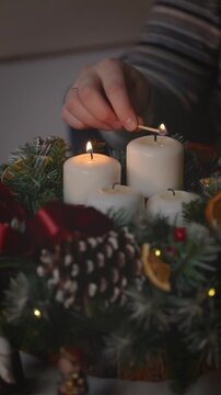 Lighting the four advent candles a symbol of the approaching Christmas. Advent wreath with candles.