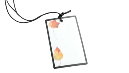 Clear, rectangular tag with autumnal leaves. Attached with black string on dark background