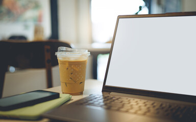 close up shot, work outside the office in cafe with laptop computer, mobile phone and ice coffee on table
