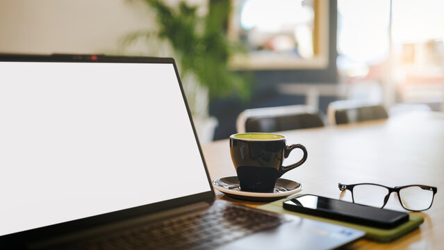 close up shot, desk office for meeting with blank screen laptop, mobile phone, coffee cup, and eyeglasses prepare for work and meetings - Powered by Adobe
