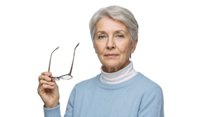 Older woman holding glasses with a serious expression in a light sweater