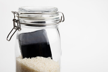 A wet smartphone is dried in rice and glass bottle on white background