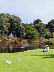 A woman sits near an ornamental lake at the Royal Botanical Gardens