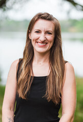 Smiling woman standing outdoors near lake