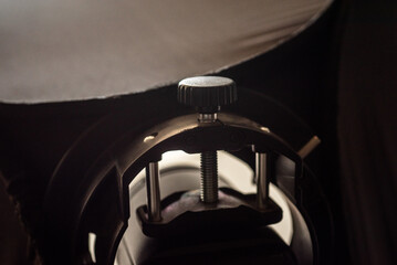 Close up of a studio flash bracket mount with adjustment screw and metal support rods