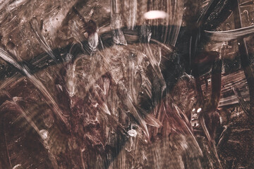 Dark abstract texture with scratches, stains and random patterns in brown and white.