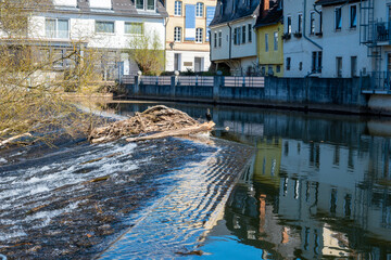 River embankment in Europe with trees, houses and much windows.