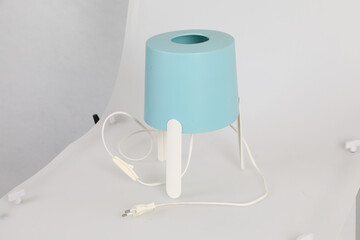 Blue table lamp on a white table.