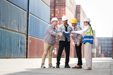 Engineer and worker team working in logistic terminal of container cargo, Diverse construction team in safety gear outdoors	