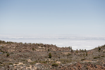 Stunning panoramic view of Tenerifes volcanic landscape, showcasing rugged terrain and lush vegetation beneath a clear blue sky