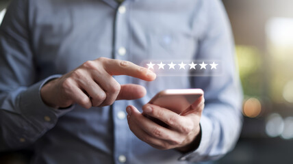 Person's hands holding a smartphone with a five-star rating being selected on the screen.