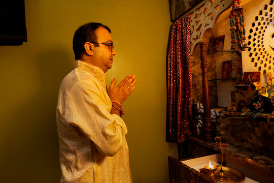 A father folds his hands in prayer during the morning worship ritual