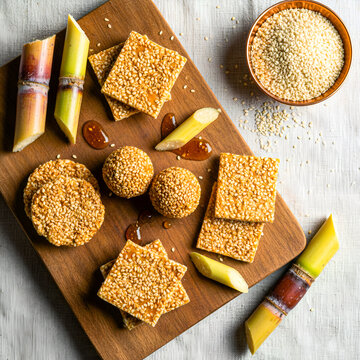 Til Gud Gajak and Til Ladoo with Sugarcane on Wooden Board