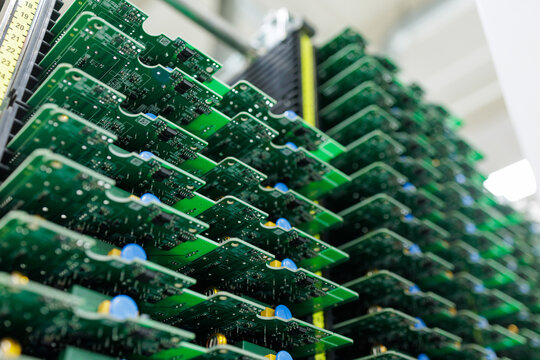 Stacks of assembled circuit boards in rack at modern electronics factory