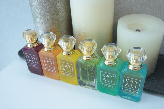 Perfume Kay Ali in bottles placed on a dressing table in front of candles.