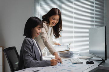 Businesswomen discussing financial data and analyzing reports