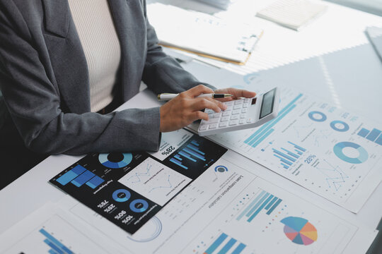 Businesswoman calculating financial data on reports