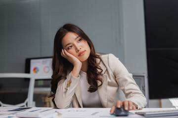 Young businesswoman feeling tired and bored at office desk
