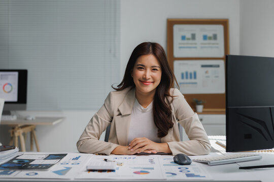 Happy businesswoman smiling evaluating financial data in office