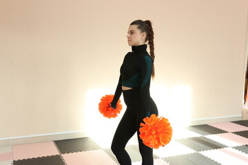 Beautiful girl doing cheerleading and pom pom dance training
