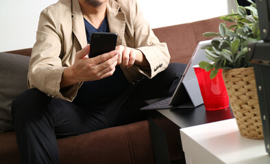 Man Using Smartphone While Working with Tablet in Casual Office Setting