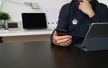 Doctor Using Smartphone and Tablet in Modern Office