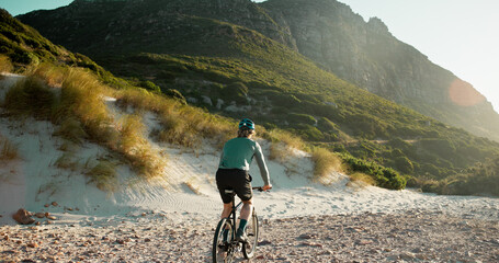 Man, bicycle or sand with mountain for cycling journey, fitness or outdoor adventure in nature. Back view, male person or cyclist with bike on rocky shore for exercise, training or ride in wilderness