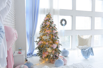 Cozy winter room with a beautifully decorated Christmas tree in soft pastel colors and bright lights