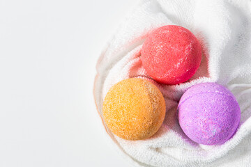 Colorful bath bombs resting on a white towel ready for relaxation and self care