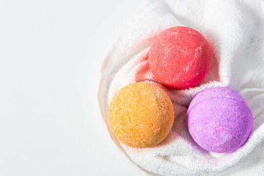 Colorful bath bombs resting on a white towel ready for relaxation and self care - Powered by Adobe