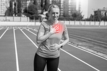 Black and white photo. Injury and pain in the chest of a female runner. A woman suffers from chest pains or symptoms of heart disease while running on a treadmill