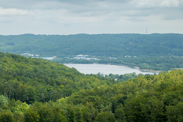An aerial view of Lake Żarnowieckie in the Kashubian region, nestled among forested hills. Poland