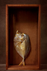 Still life with smoked sea fish in a wooden box