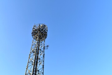 Looking up at a mobile phone tower on a sunny day.