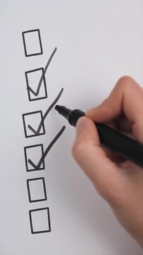 Person checking off boxes with marker on a list, suitable for productivity, organization, planning, completion, success, achievement concepts.