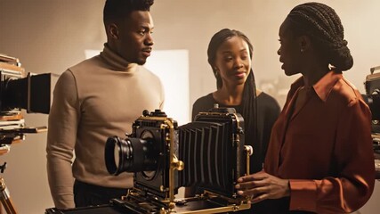 African individuals operating large format cameras in photography studio