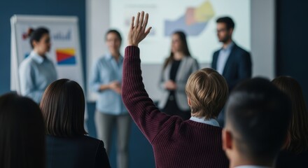 Audience member raising hand during business presentation in conference room with diverse group of people and charts