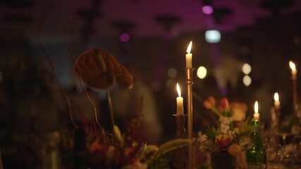 Elegant festive table arrangement with burning taper candles and soft bokeh lights in the background. Warm atmosphere, floral decoration and evening celebration mood. - Powered by Adobe