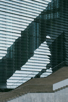 Along the facade of a modern building, architecture organizes stairs and staircase as structure guided by geometry and design, letting minimalism emphasize architectural detail over urban space