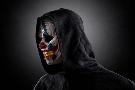 Portrait of a scary clown over dark misty background with clipping path