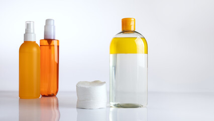 Minimalist scene featuring a two-phase makeup remover with oil and cotton pads