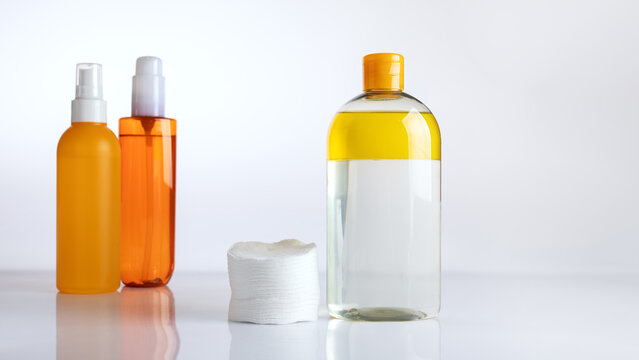 Minimalist scene featuring a two-phase makeup remover with oil and cotton pads