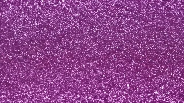 A mesmerizing and vibrant abstract background features countless shimmering purple glitter particles. This sparkling texture creates a dynamic and celebratory visual effect, with individual specks ref