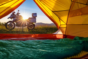 Motorcycle trip to the mountains with a tent. Beautiful sunset in the mountains.