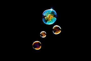 Transparent Bubble Containing Earth Map with Smaller Bubbles on Black Background - Abstract Globe Concept Photography Showing World Inside Bubble with Reflections and Light