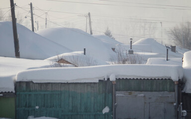 Old private houses built in the Soviet era covered with snow. Roofs of houses covered with snow. After a heavy blizzard. Ust-Kamenogorsk (kazakhstan)