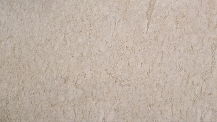 A close-up view of a natural stone surface with a soft beige tone and subtle veining patterns.