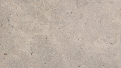 A close-up view of a textured concrete surface with natural variations in tone and grain.
