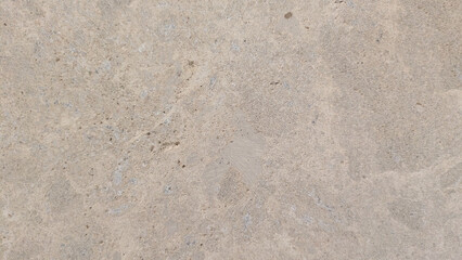 Close-up of a textured concrete surface with natural imperfections and subtle variations in tone.